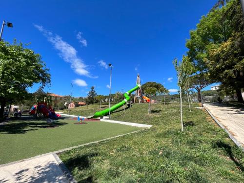 um parque infantil com um escorrega verde num parque em Casa Lollo em Chiavari