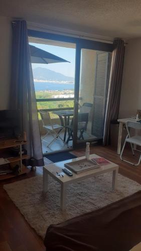 - un salon avec une table devant une grande fenêtre dans l'établissement Charmant studio, à Grosseto-Prugna