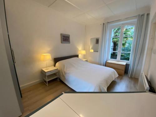 una camera bianca con un letto e una finestra di St Guenole' Studio Apartment a Landévennec