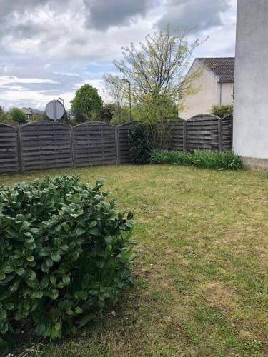 een tuin met een hek en een struik bij Maison indépendante avec jardin in Le Mans