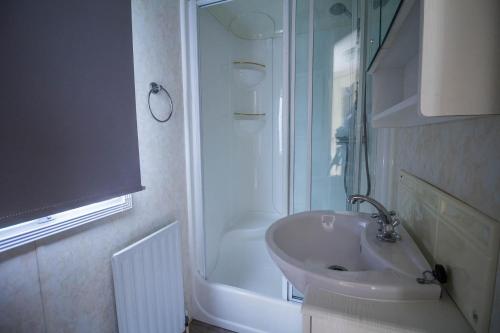 a bathroom with a sink and a shower at Brilliant Caravan For Hire At Manor Park In Hunstanton Norfolk Ref 23176k in Hunstanton