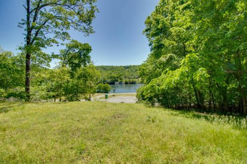 a grassy field with a river in the background at Spacious White Rivers Jewel Fishing Haven! in Flippin