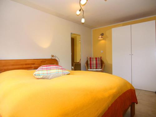 1 dormitorio con 1 cama amarilla y 1 silla en Ferienhaus in Krusendorf, en Krusendorf