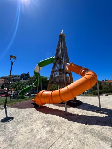 a playground with an orange slide in a park at Casa Lollo in Chiavari