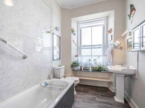 a bathroom with a tub and a sink and a toilet at Pier Haven in Blairmore