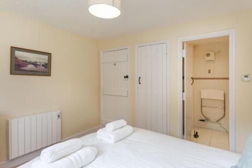 a bedroom with a white bed with towels on it at Burnham B in Blakeney