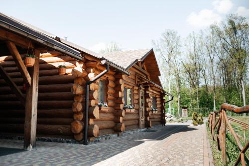 a log cabin with a fence in front of it at Ray Eco Resort in Mukacheve