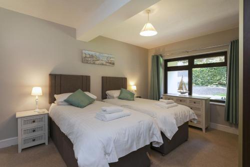 a bedroom with two beds and a window at Burnham A in Blakeney