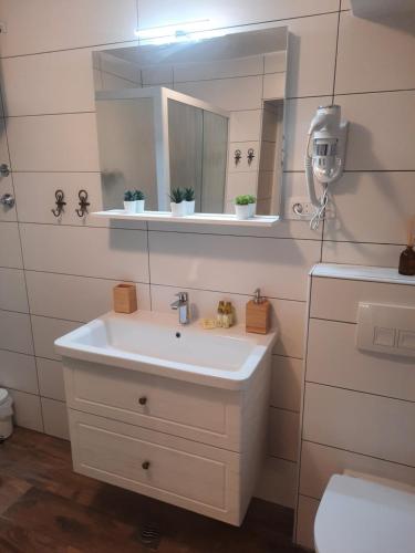 a bathroom with a white sink and a mirror at Old Town Rab Studio apartment in Rab