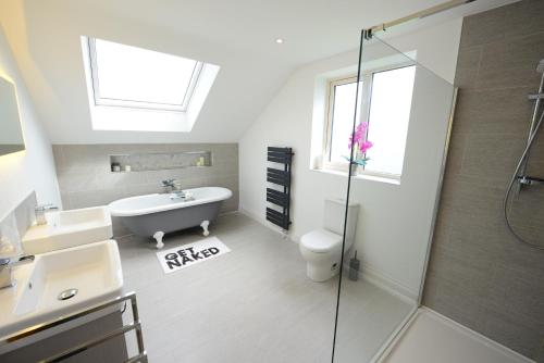 a bathroom with a tub and a sink and a shower at Rollestone New Forest (HOT TUB) in Salisbury