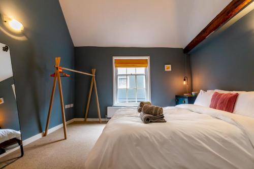 un osito de peluche sentado en una cama en un dormitorio en Princes Cottage en Norwich