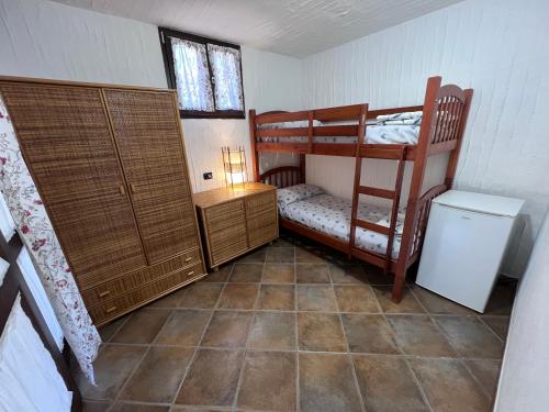 Kleines Zimmer mit 2 Etagenbetten und einem Kühlschrank. in der Unterkunft Almà in Torre delle Stelle