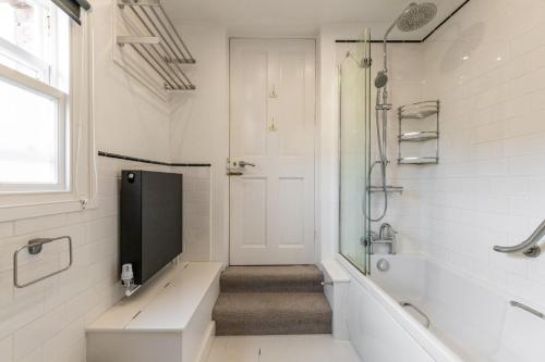 a bathroom with a shower and a toilet and a sink at Norfolk Historic Townhouse in Kings Lynn