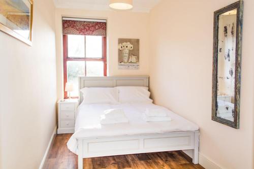 uma cama branca num quarto com uma janela em Rosary Road Apartment em Norwich