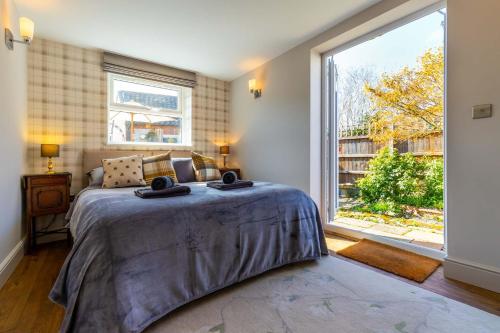 1 dormitorio con cama y ventana grande en St Josephs Cottage en West Runton