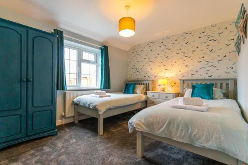 a bedroom with two beds and a fish wall at The Courtyard in Snettisham