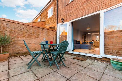 a patio with a table and chairs in front of a brick wall at The Courtyard in Snettisham