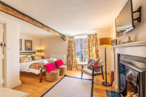 a bedroom with a bed and a fireplace at Host & Stay - The Old Paul Pry in Holt