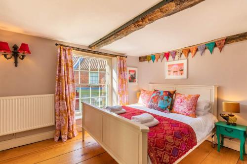 a bedroom with a bed and a window at Host & Stay - The Old Paul Pry in Holt