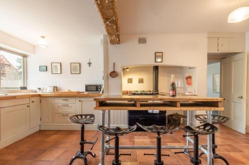a kitchen with a counter and two bar stools at Host & Stay - Mill House in East Dereham
