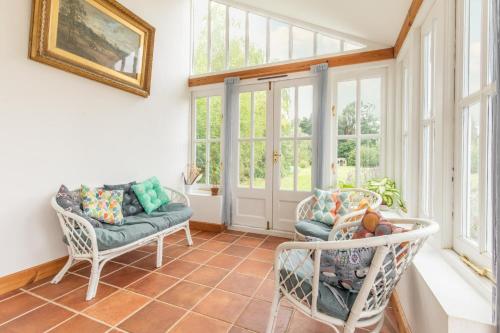 a sun room with two chairs and windows at Host & Stay - Mill House in East Dereham