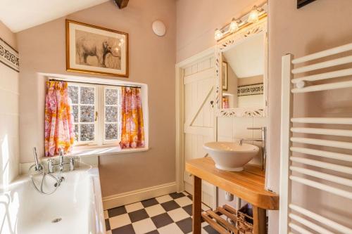 een badkamer met een bad en een wastafel bij The Old Paul Pry in Holt