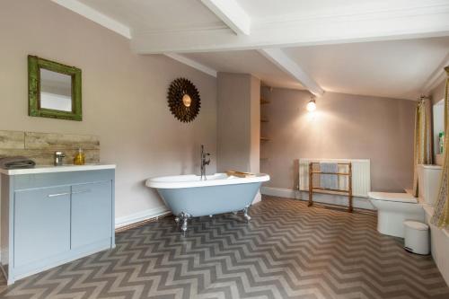 a bathroom with a tub and a sink and a toilet at Mill House in East Dereham