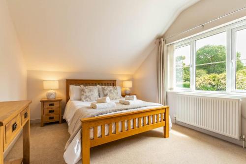 a bedroom with a bed and a large window at Woodside House in Costessey