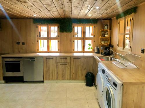 a kitchen with a sink and a dishwasher at Попската къща-възрожденски дух и съвременни удобства in Medven