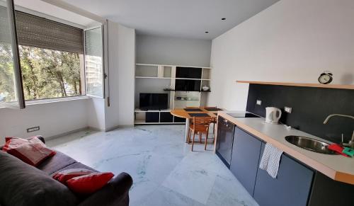 eine Küche und ein Wohnzimmer mit einem Sofa und einem Tisch in der Unterkunft Vignola New Apartment in Rom