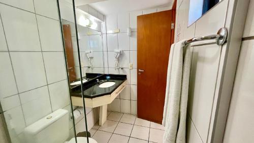 La salle de bains est pourvue d'un lavabo, de toilettes et d'un miroir. dans l'établissement Paradise 204 Praia Flat - NBI - Vista x Mar Ponta Negra, à Natal