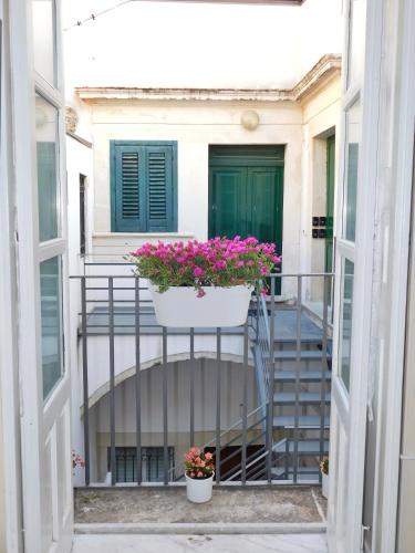 a balcony with flowers in a pot on a railing at Camere A’ Marina in Siracusa