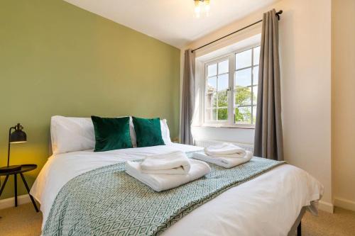 1 dormitorio con 1 cama con toallas en Abbey Farm Cottages en Bacton