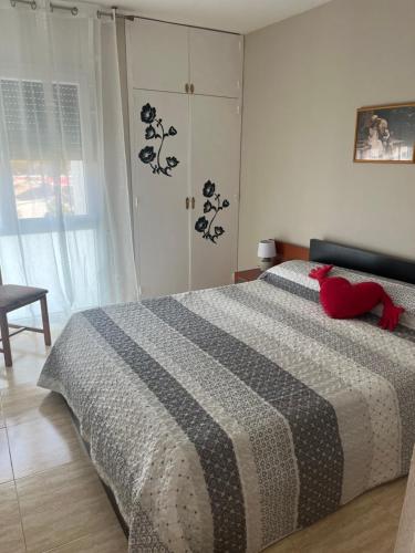 um quarto com uma cama com um bicho de peluche vermelho em Apartamento Hifrensa em L'Hospitalet de l'Infant