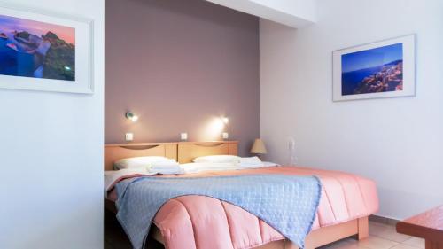 um quarto com uma cama rosa num quarto em Anchris Paleochora em Palaiochora