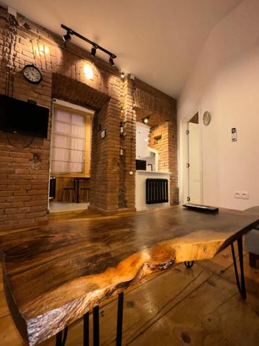 a wooden table in a room with a brick wall at Salalak in Tbilisi City