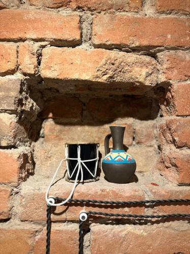 a brick wall with a vase and a drum at Salalak in Tbilisi City