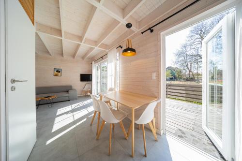 a dining room with a wooden table and chairs at Babki z Piasku in Dziwnów