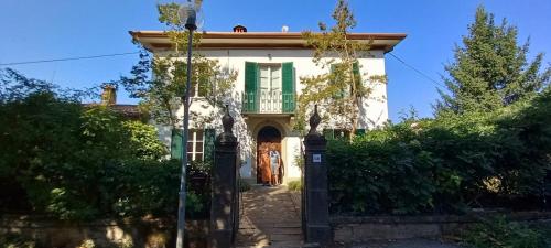 a white house with a green window and a door at Villa Pavone in Coreglia Antelminelli