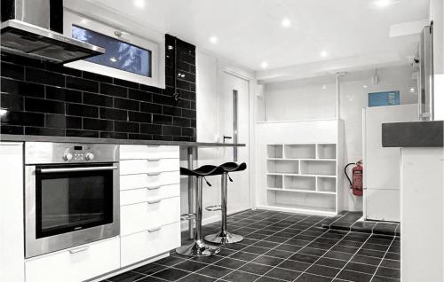 een keuken met witte kasten en een zwarte tegelvloer bij 1 Bedroom Stunning Apartment In Jrflla in Järfälla