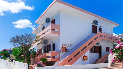 a building with stairs and flowers in front of it at Anchris Paleochora in Palaiochora