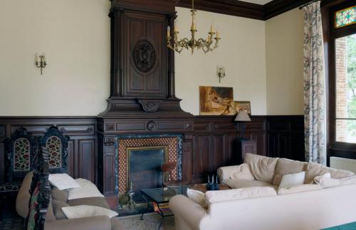 a living room with white couches and a fireplace at Chateau de Vaugelas - Charmant domaine près de Valence in Alixan