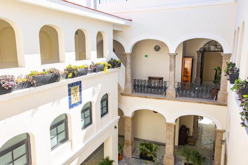 an apartment building with balconies and potted plants at Palpatio Hotel in Guadalajara