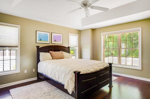 a bedroom with a bed with a ceiling fan and windows at Plantations East - 221 Lakeside Dr in Lewes