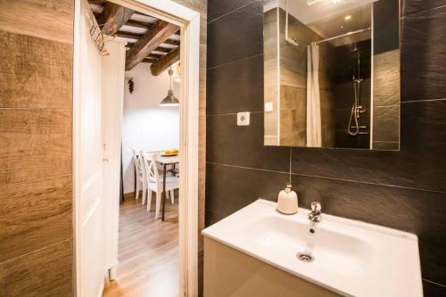 a bathroom with a sink and a mirror and a table at Prive terrace in El Born, near the beach in Barcelona