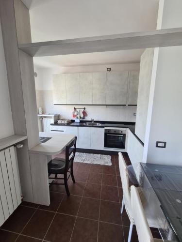 a kitchen with white cabinets and a table and chairs at Milano Santa Giulia Business Apartment - Olimpiadi 26 in Milan