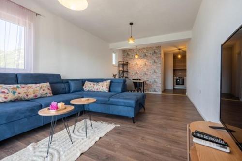 a living room with a blue couch and tables at Vuletić in Neum