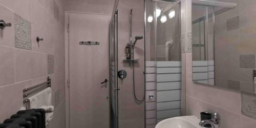 La salle de bains est pourvue d'une douche et d'un lavabo. dans l'établissement Charming apartment in a 19th century villa, à Trieste