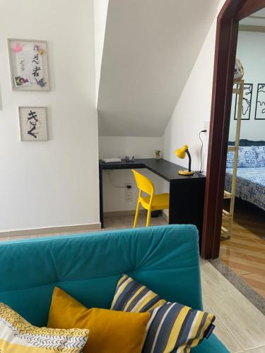 un soggiorno con divano blu e una camera da letto di Wabisabi Residence ad Araxá