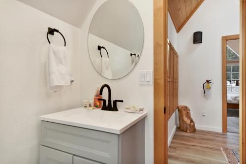 a bathroom with a sink and a mirror at Green Canoe Cabin- Hot Tub- Smart TVs- BBQ- Relaxing Central Moonridge Chalet in Big Bear Lake